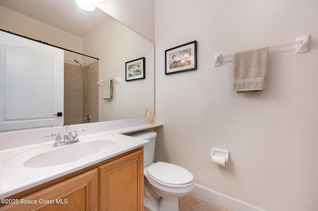 bathroom with toilet, vanity, and tiled shower