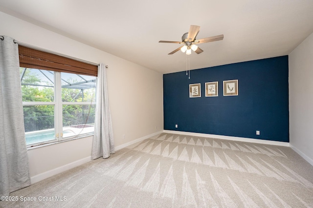 empty room with a healthy amount of sunlight, light colored carpet, and ceiling fan