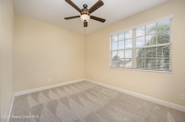 carpeted spare room with ceiling fan