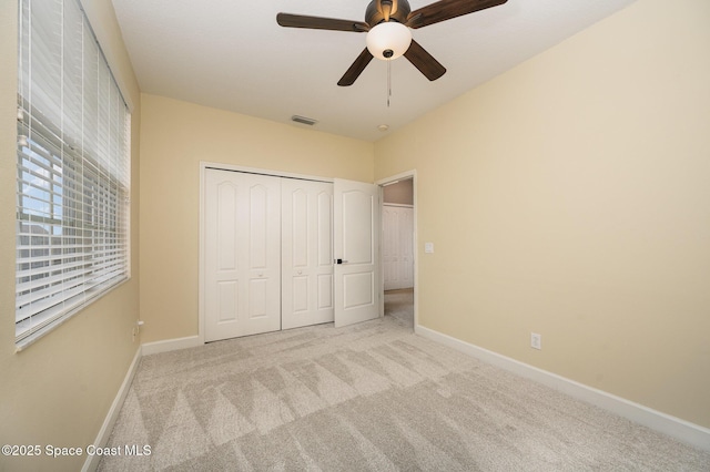 unfurnished bedroom featuring light carpet, a closet, and ceiling fan