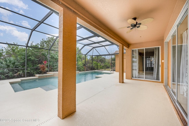 view of pool with glass enclosure, ceiling fan, and a patio area