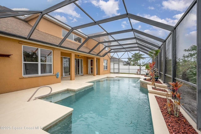 view of pool featuring glass enclosure and a patio area