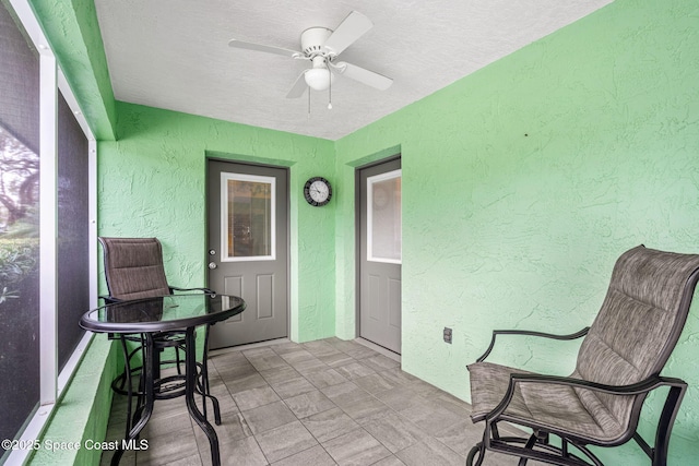 sunroom featuring ceiling fan