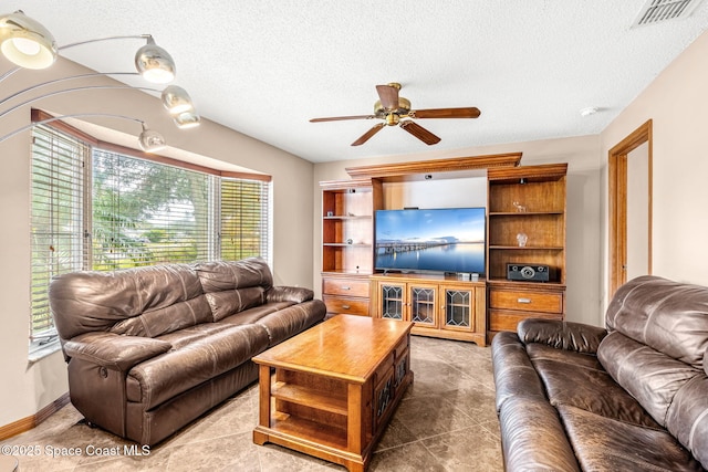 living room with a textured ceiling and ceiling fan