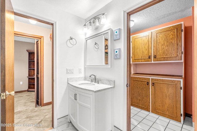 bathroom featuring vanity, tile patterned floors, and a textured ceiling