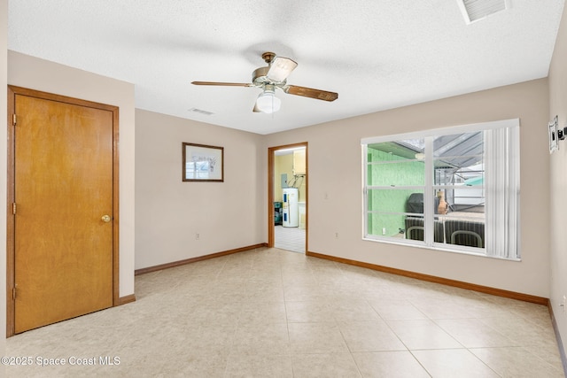 empty room featuring a textured ceiling, electric water heater, and ceiling fan