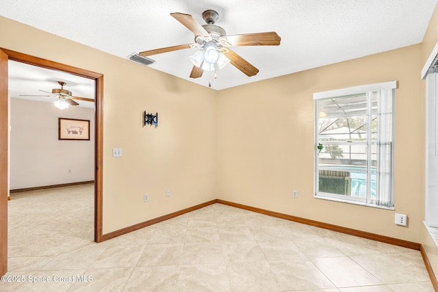 tiled spare room featuring ceiling fan and a textured ceiling