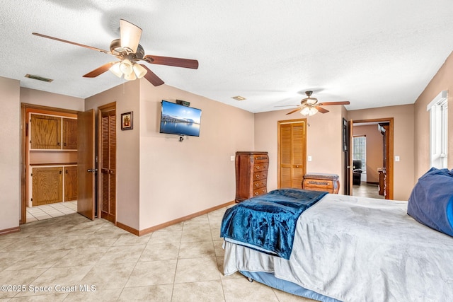 bedroom with light tile patterned floors, a textured ceiling, and ceiling fan