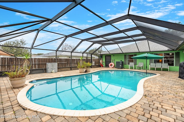 view of swimming pool with a patio, a lanai, and central AC