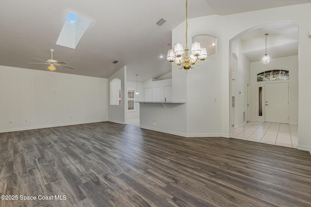 unfurnished living room featuring a textured ceiling, high vaulted ceiling, ceiling fan with notable chandelier, and hardwood / wood-style flooring