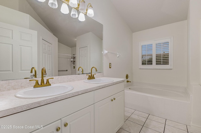 bathroom featuring tile patterned flooring, a tub, lofted ceiling, and vanity