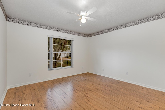 spare room featuring a textured ceiling, light wood-type flooring, and ceiling fan