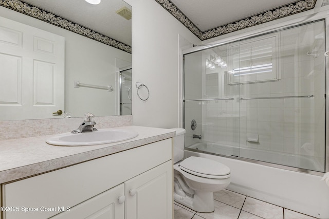 full bathroom featuring tile patterned flooring, toilet, vanity, bath / shower combo with glass door, and a textured ceiling