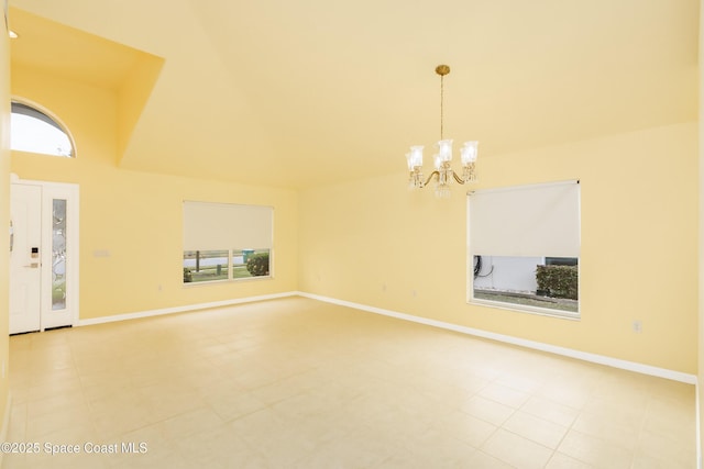 unfurnished living room featuring light tile patterned flooring, a chandelier, and plenty of natural light