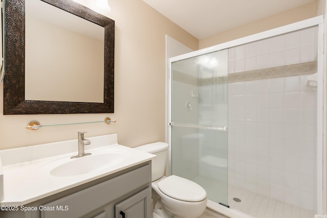 bathroom featuring toilet, walk in shower, and vanity