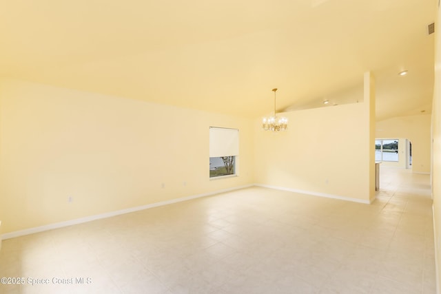 tiled empty room with a notable chandelier and vaulted ceiling