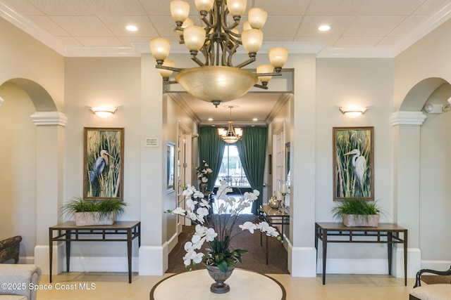 interior space with an inviting chandelier, crown molding, and ornate columns