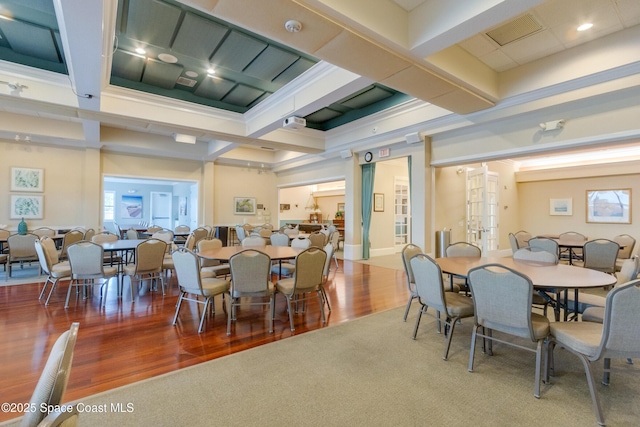 dining space featuring coffered ceiling, hardwood / wood-style flooring, and beam ceiling