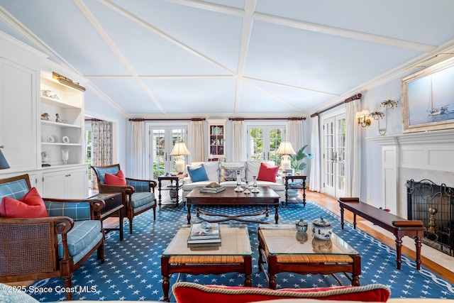 sunroom featuring a high end fireplace, french doors, and lofted ceiling