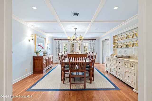 dining room featuring coffered ceiling, light hardwood / wood-style floors, an inviting chandelier, crown molding, and beamed ceiling