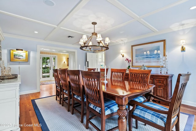 dining space featuring a chandelier, light hardwood / wood-style floors, and coffered ceiling