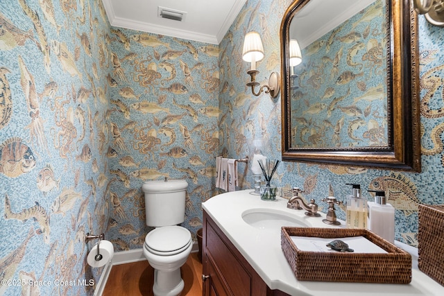 bathroom featuring toilet, ornamental molding, wood-type flooring, and vanity