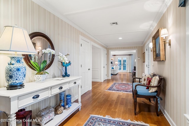 hall with light hardwood / wood-style floors and crown molding