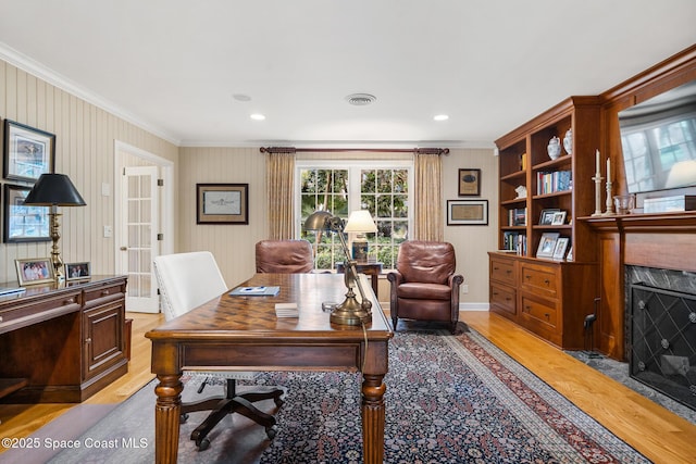 office space featuring a high end fireplace, ornamental molding, and light hardwood / wood-style floors