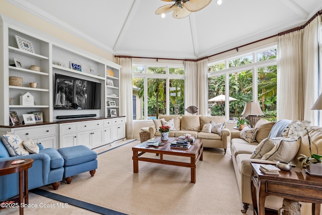 living room featuring lofted ceiling, ceiling fan, ornamental molding, and a healthy amount of sunlight