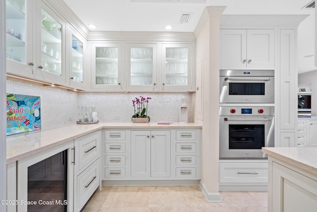 kitchen with white cabinets, stainless steel double oven, and wine cooler