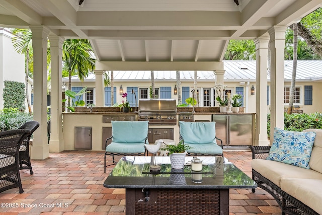 sunroom / solarium featuring sink, lofted ceiling with beams, and decorative columns