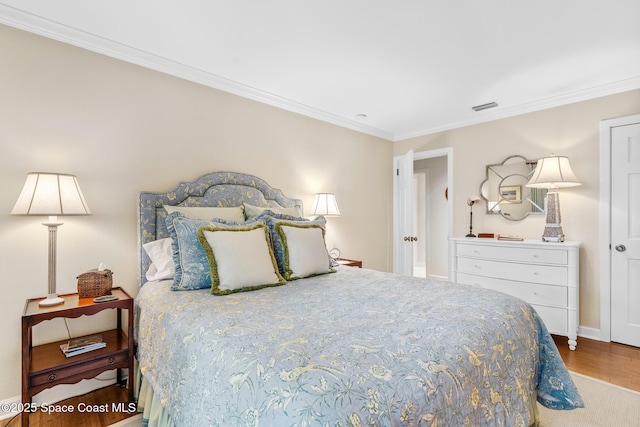 bedroom with wood-type flooring and crown molding