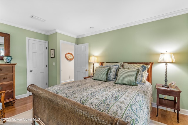 bedroom featuring ornamental molding and light hardwood / wood-style flooring