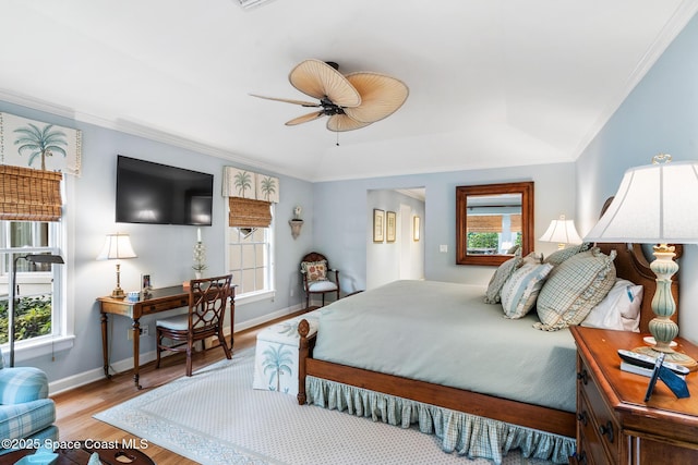 bedroom featuring multiple windows, ceiling fan, crown molding, and light hardwood / wood-style flooring