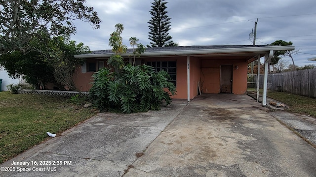 view of front of house featuring a carport and a front lawn