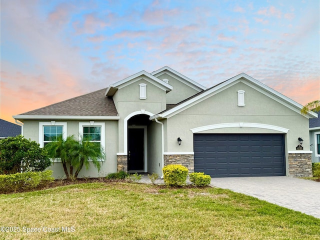 view of front of home with a garage and a yard