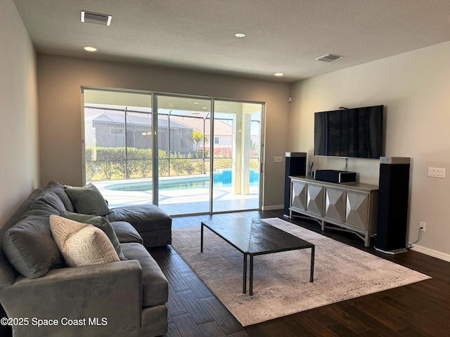 living room featuring dark hardwood / wood-style flooring and a textured ceiling