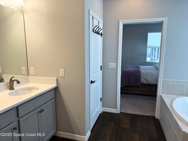 bathroom featuring vanity, hardwood / wood-style floors, and tiled bath