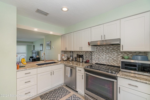 kitchen featuring white cabinets, appliances with stainless steel finishes, tasteful backsplash, and sink