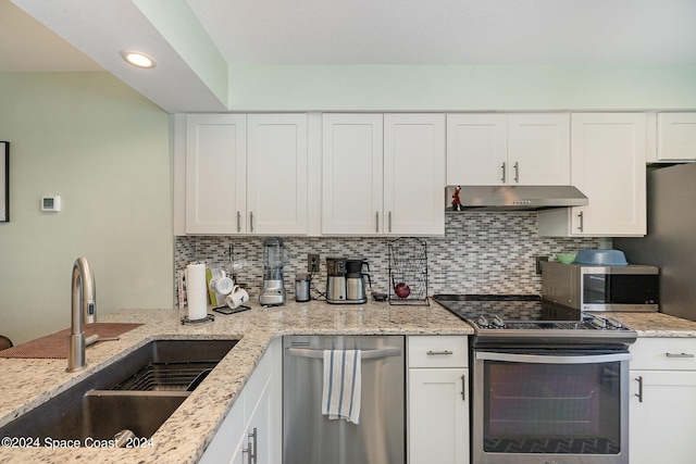 kitchen featuring stainless steel appliances, white cabinets, decorative backsplash, and sink