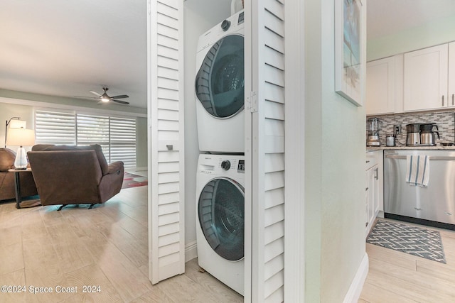 clothes washing area with stacked washer and clothes dryer, ceiling fan, and light hardwood / wood-style flooring