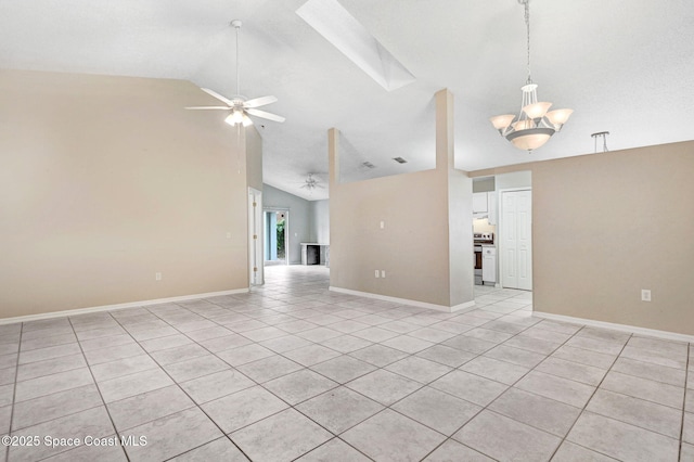 empty room with ceiling fan with notable chandelier, light tile patterned flooring, and lofted ceiling