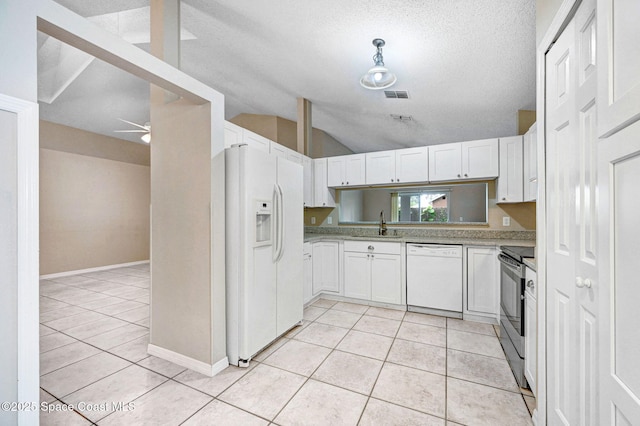 kitchen with white appliances, vaulted ceiling, ceiling fan, a textured ceiling, and white cabinets