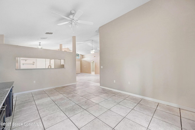 spare room featuring lofted ceiling, ceiling fan, and light tile patterned floors