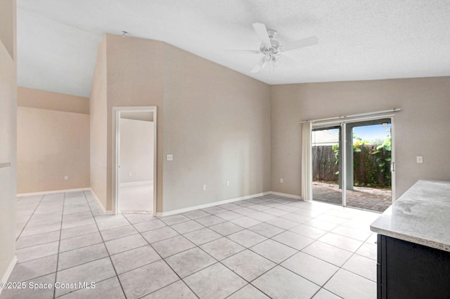 unfurnished living room featuring a textured ceiling, ceiling fan, vaulted ceiling, and light tile patterned floors