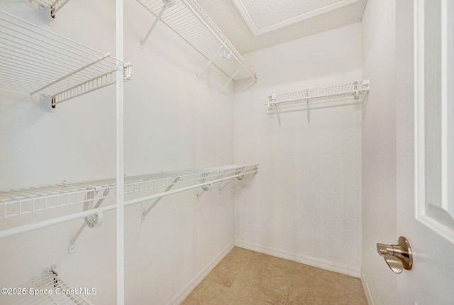 spacious closet with light tile patterned floors