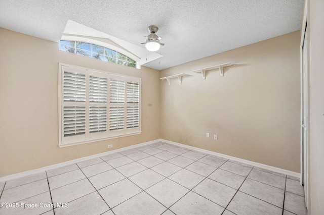 tiled spare room featuring a textured ceiling and lofted ceiling