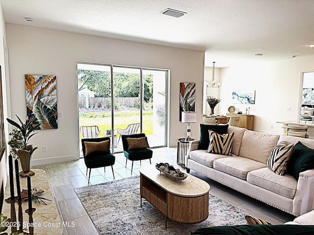 living area featuring a textured ceiling, baseboards, and visible vents