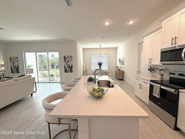 kitchen featuring recessed lighting, a sink, light wood-style flooring, and appliances with stainless steel finishes