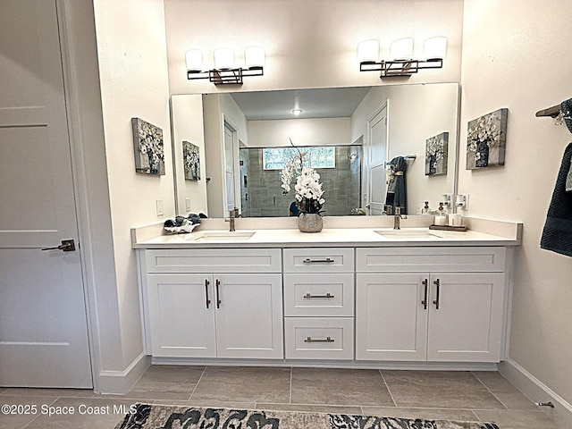 bathroom featuring double vanity, baseboards, a sink, and a stall shower